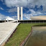Vista do Congresso Nacional do Brasil, com suas cúpulas e edifícios modernos sob um céu claro.