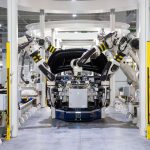 Robôs trabalham na montagem de um automóvel em uma fábrica moderna.