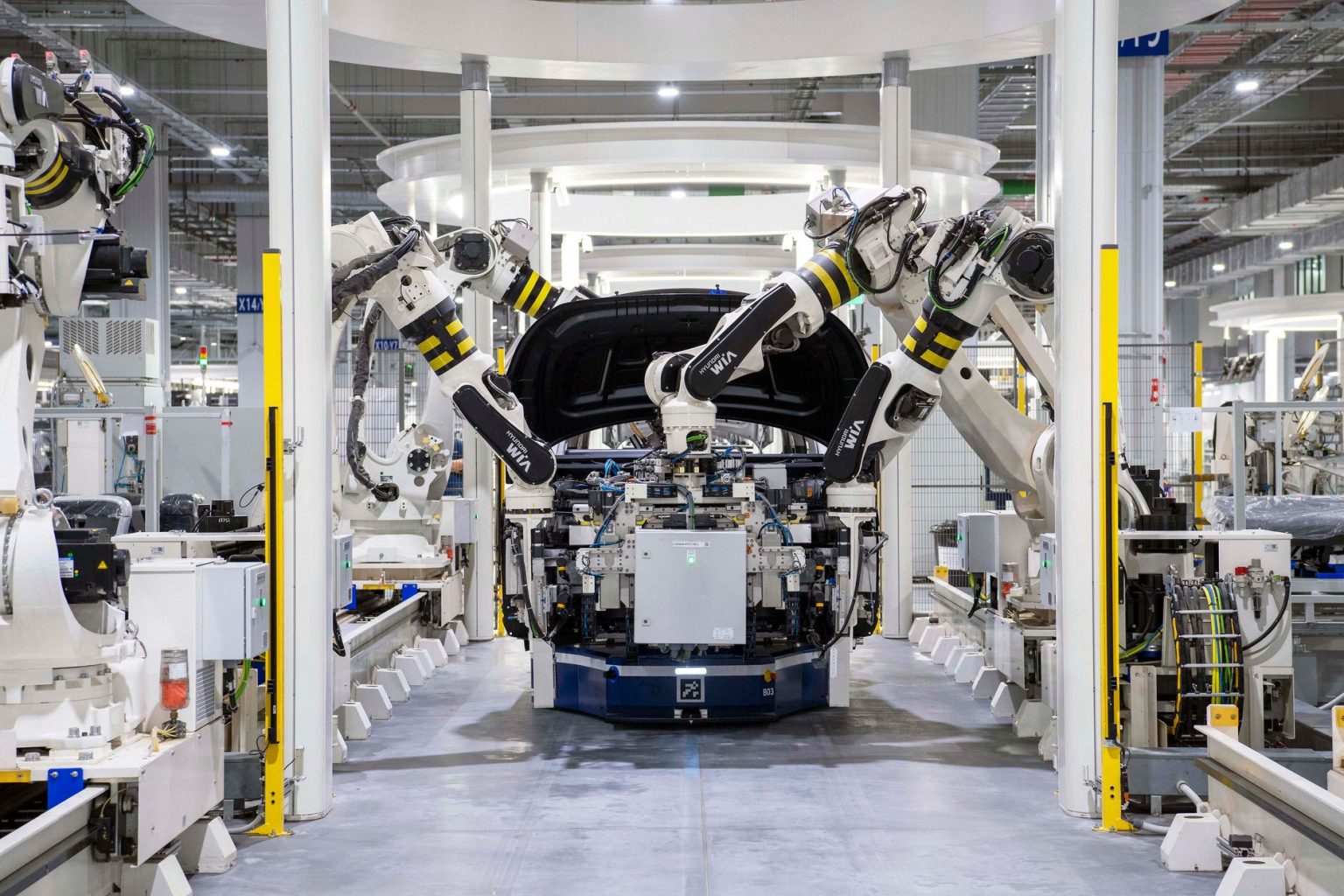 Robôs trabalham na montagem de um automóvel em uma fábrica moderna.
